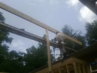 Carpenter setting a ridge beam over a new addition frame — Ice Dam Removal by Roofing Brothers in Waltersburg