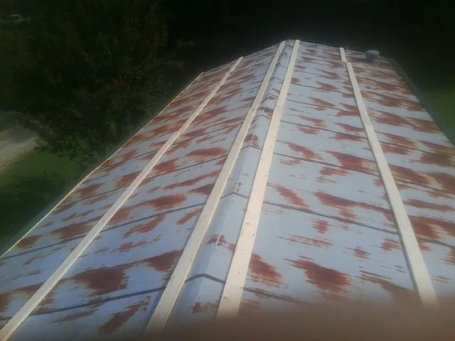 Rusted metal roof panels with new wood purlins before replacement — Storm Damage Roof Repair in Waltersburg by Roofing Brothers