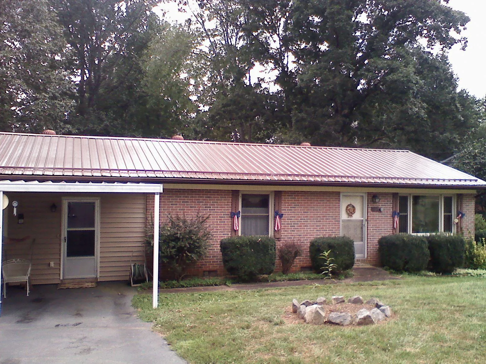 Bronze metal roof and carport on a brick ranch home — Roof Repair work by our crew in Waltersburg